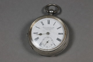 An open faced pocket watch with Roman numerals by Kendal & Dent contained in a "silver" case