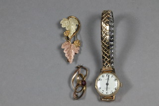 A lady's Verity wristwatch contained in a gold case and 2 gilt metal brooches