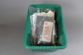 A green crate containing a collection of coins and bank notes