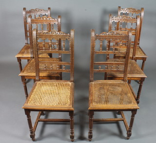 A matched set of 6 Continental oak dining chairs with foliate carved cresting rails, spindle spars above cane seats, on turned  fluted legs