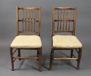 A near matching set of 7 18th Century rush seated spindle back  chairs, having baluster turned spindle backs, fitted loose cushions  above rush seats on turned legs with pad feet
