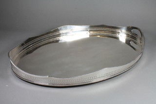 An Edwardian oval silver plated twin handled galleried tea tray  24"