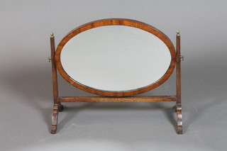 An oval plate dressing table mirror contained in a mahogany  swing frame 18" x 16"