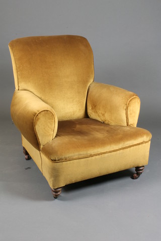 A Victorian armchair upholstered in gold dralon, on turned feet