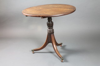 A 19th Century circular mahogany tilt top tea table raised on a turned column and tripod base ending in brass caps and casters  29"h x 30.5"diam.