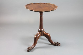 A Georgian style circular mahogany wine table with pie crust edge, raised on a turned column and tripod base with egg and  claw feet 18"