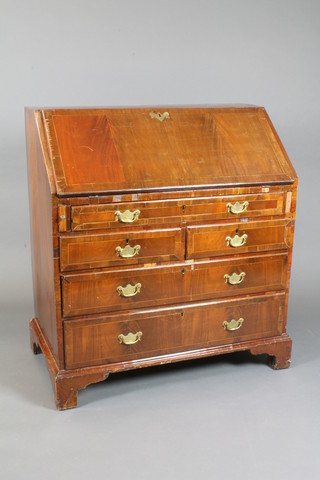 A Georgian mahogany bureau, crossbanded, the fall enclosing a  fitted interior above 2 short and 3 long drawers, raised on bracket  feet 40"h x 36"w x 20"d