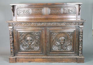 A Victorian carved oak sideboard with raised back, the base  fitted a pair of panelled doors, 50"h x 65"w x 19"d