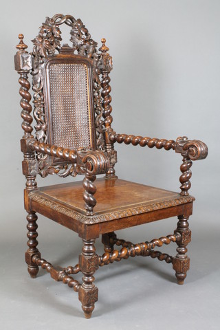 A Victorian heavily carved oak Carolean style open arm chair with cane back, raised on spiral turned and block supports
