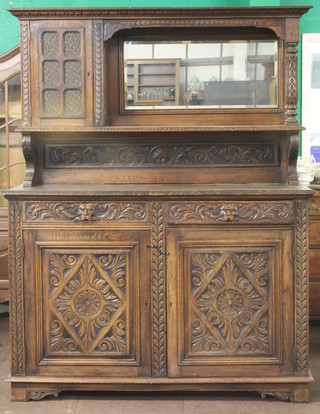 A Victorian carved oak sideboard, the raised back with moulded cornice, fitted a mirror and flanked by glazed panelled doors,  the base fitted 2 long drawers above a double cupboard 58"w x  23"d