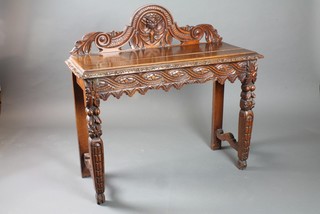 A 19th Century Continental carved and pierced oak hall table with raised back on square tapering supports 39"h x 41"w x 16"d
