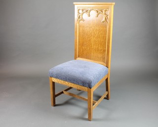 A honey oak Gothic high backed chair with upholstered seat, raised on square tapering supports