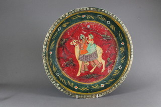 An Indian circular papier mache bowl decorated a couple riding a  camel 14"
