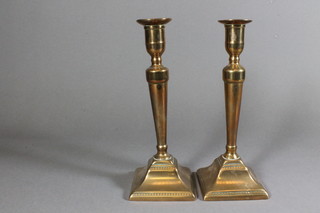 A pair of 18th/19th Century brass candlesticks with ejectors on  raised on spreading feet 10"