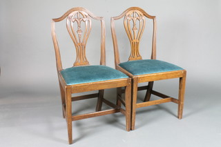 A pair of Hepplewhite style shield back dining chairs on square tapering supports with H framed stretcher