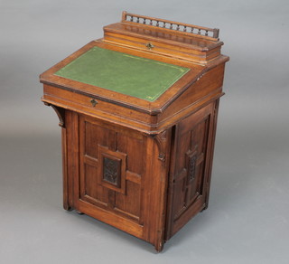 A late Victorian mahogany and birdseye maple Davenport desk with hinged top enclosing pigeon holes above a fall enclosing 2  short drawers, the side fitted a foliate carved panelled door  enclosing 4 short drawers, raised on casters