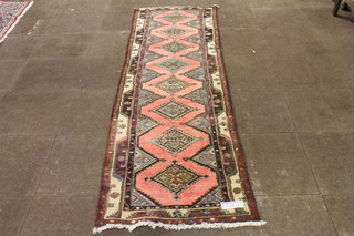 A pink ground Bokhara style runner, the field decorated with 8  floral lozenges, multi bordered and fringed, 108"l x 32"w