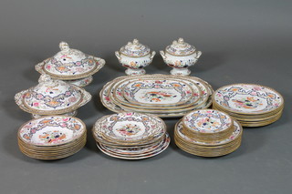 A Mintons 45 piece part dinner service comprising 2 sauce tureens and covers, 8 soup dishes, a pair of rectangular serving  dishes, 8 side plates, 8 small side plates, 2 sandwich plates, 8  large dinner plates, 2 tureens and covers and a graduated set of 4  meat plates, decorated in the Imari palette and centred with an  urn of flowers within gilt heightened foliate reserves, together  with 3 Amherst Pottery Japanese pattern plates of similar  decoration