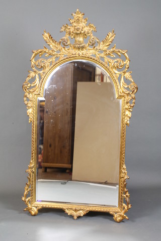 An arch shaped bevelled plate wall mirror contained in a gilt carved wood frame 30"w x 56"h