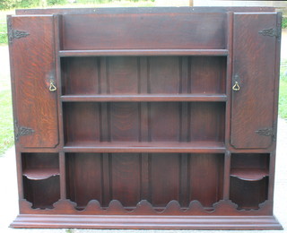 An Art Nouveau oak dresser back with moulded cornice fitted 4 shelves and with panels to the side, 62"w x 8"d x 48.5"h