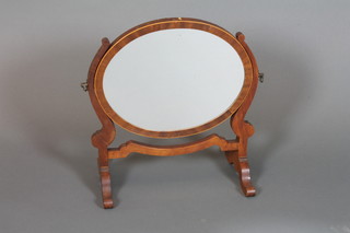 An oval plate dressing table mirror contained in a mahogany  swing frame 15"h x 15"w