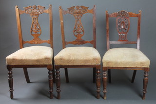 A set of 3 matched Edwardian carved walnut dining chairs with pierced vase shaped slat backs and upholstered seats, raised on  turned supports