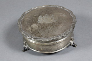 A circular silver dressing table jar with hinged lid raised on hoof  supports, decorated the Arms of the Worshipful Company of  Carpenters, Birmingham 1925