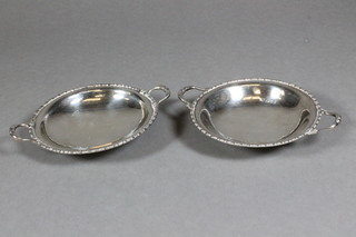 A matched pair of silver twin handled dishes, London 1921 and  1924, 3 ozs