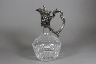 A cut glass claret jug with silver plated mount
