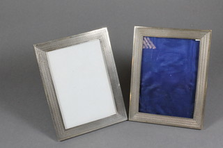 A pair of silver easel photograph frames with engine turned decoration, London 1910, retailed by Wilson & Gill of Regent  Street