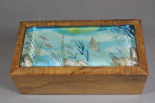 Ben Shillingford for Dunhill, a walnut aquarium cigar box, the hinged top inset a lucite panel depicting flying and angel fish  amongst a sub-aquatic setting, 3"h x 8.5"w x 4.25"d   ILLUSTRATED