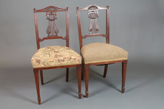 A pair of late Victorian walnut dining chairs in the Sheraton style  with carved and pierced splats, stuff over seats, on square tapered  legs, spade feet