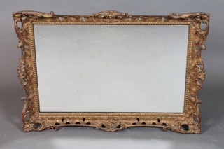 An early 18th Century style carved giltwood wall mirror in the Rococo taste having foliate and scroll carved frame inset  rectangular plate 22"h x 31.5"w
