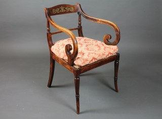 A Regency simulated rosewood elbow chair, the cresting rail decorated with foliate cut brass inlay, with scroll arms, cane seat  and raised on ring turned tapered splayed legs