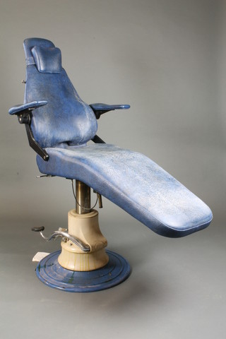 A mid 20th Century pneumatic dentist's chair with blue leatherette upholstery, raised on a circular spreading base