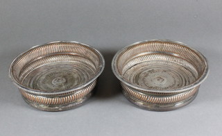 A pair of 19th Century circular silver plated wine bottle coasters with armorial decoration