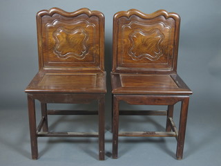 A set of 4 late 19th Century Chinese carved Padouk wood chairs, having shaped cresting rails above quatrefoil carved backs, solid  seats on square legs united by stretchers