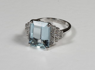 An 18ct white gold dress ring set a rectangular cut aquamarine surrounded by diamonds approx 6/0.30ct