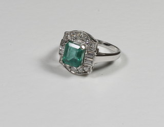 A lady's 18ct white gold dress ring set a rectangular cut emerald and with 6 baguette cut emeralds to the shoulders and surrounded  by numerous diamonds, approx 2/0.80ct