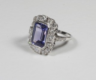 A lady's 18ct yellow gold dress ring set a rectangular cut tanzanite supported by diamonds approx 5/1.40ct
