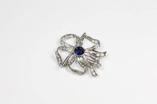 A white gold brooch of floral form set diamonds and a sapphire to  the centre