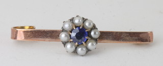 A gold bar brooch set a sapphire surrounded by demi-pearls