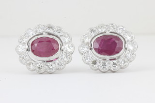 A pair of lady's white gold earrings set oval cut rubies  surrounded by diamonds approx 2ct/0.85ct