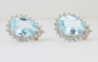A pair of 9ct earrings set tear drop cut topaz surrounded by  diamonds