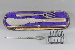 A pair of silver plated fish servers, cased, a silver plated 5 bar toast rack and a button hook