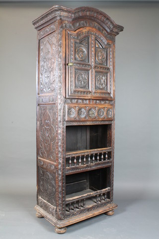 A 19th Century low countries carved walnut cabinet, the upper section with panelled door above a drawer with recess below, on  bun feet 83"h x 33"w x 20"d