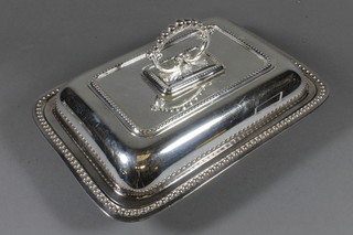 A silver plated entree dish and cover with bead work border