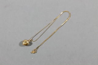 A gilt pendant hung on a 14ct fine gold chain