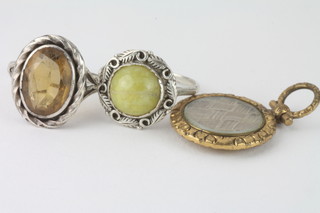 A silver ring set an amber stone, 1 other set a cabouchon cut  stone and a gilt metal locket with woven hair panel