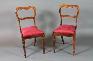 A pair of early Victorian rosewood buckle back dining chairs  with foliate carved spars, Trafalgar seats, raised on turned  tapered legs, peg feet